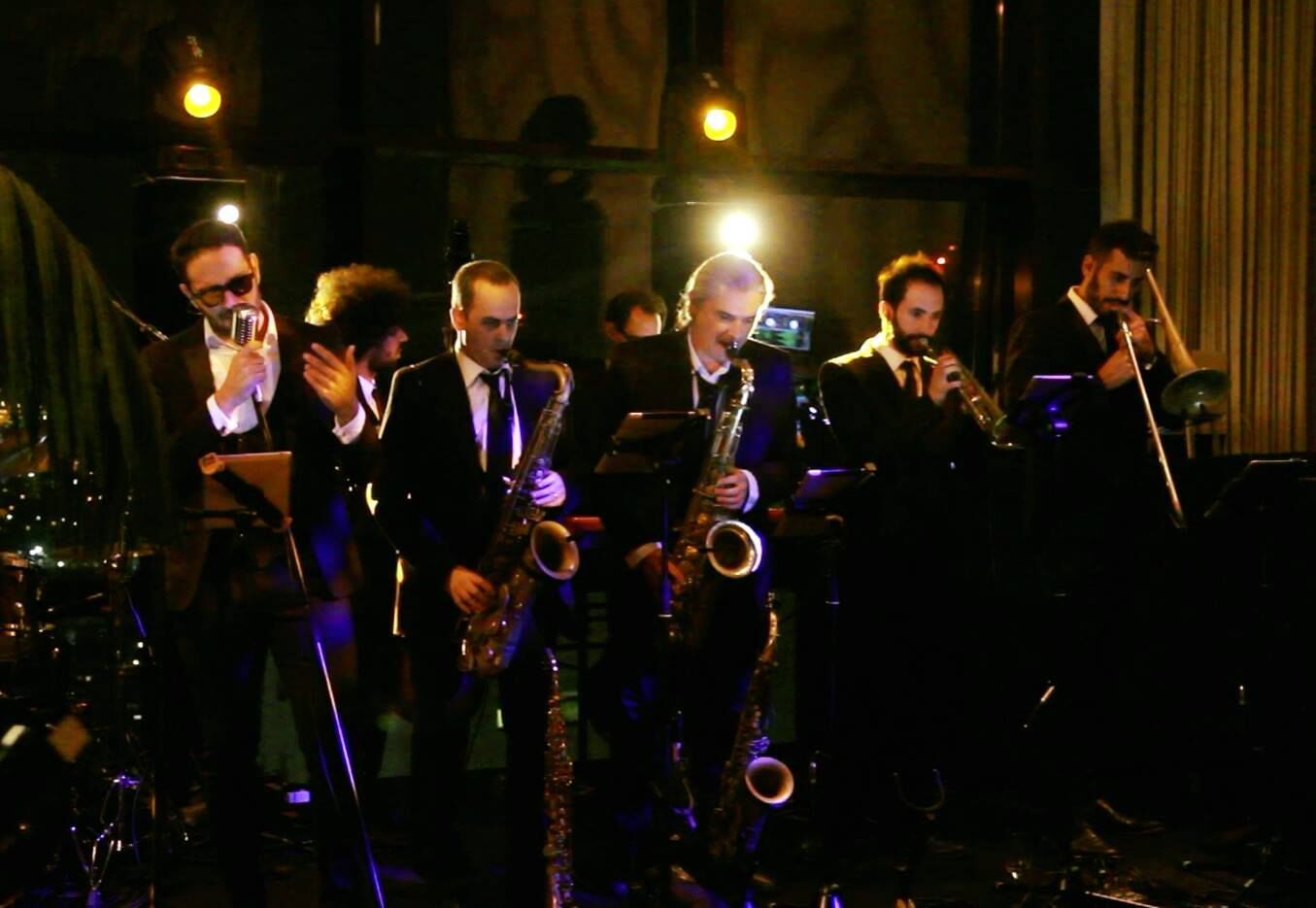 Une section de cuivres en costume lors d'une soirée
