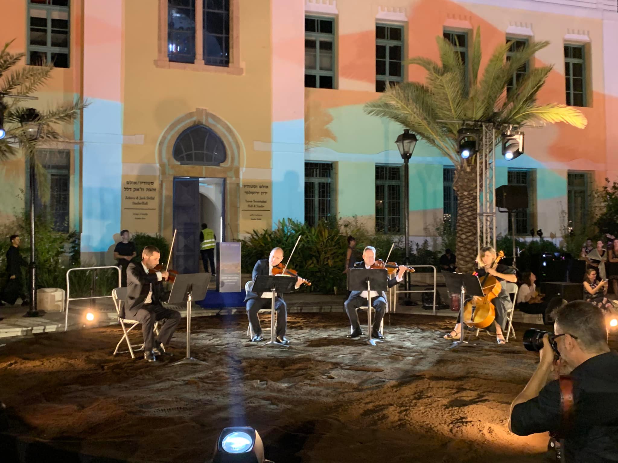 Un quatuor à cordes dans une cour illuminée, lors d'une soirée