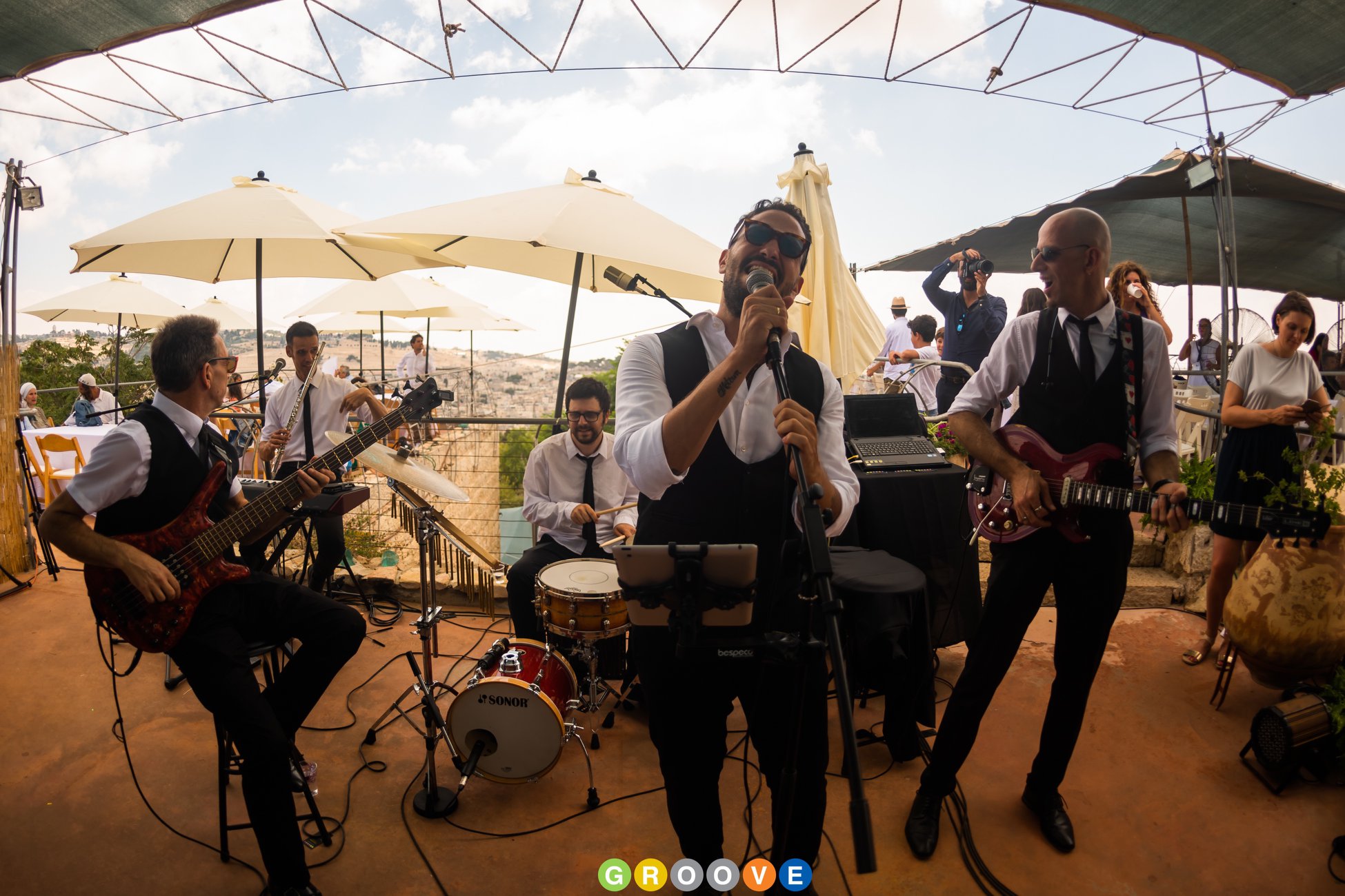 Une formation live lors d'un cocktail en journée, sous des parasols